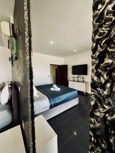 ein Hotelzimmer mit Bett und Fernseher in der Unterkunft Villa Alana in Bora Bora