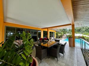 a patio with a table and chairs and a pool at Villa Alana in Bora Bora