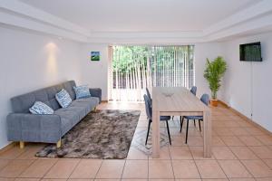 een woonkamer met een bank en een tafel bij Sandton Elite Stay in Sandton