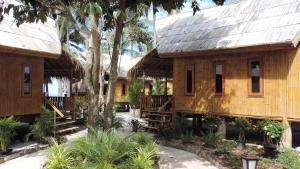 a large wooden house with trees and plants at Lazy Days Bungalows in Ko Lanta