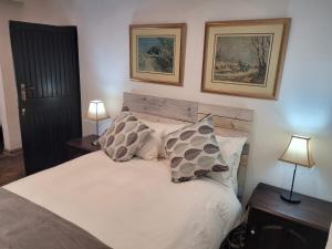 een slaapkamer met een bed met 2 lampen en 2 foto's bij Lionsgate Estate Cottage in Dargle +18 foto's
