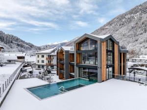 a house in the snow with a swimming pool at Monroc Hotel in Commezzadura