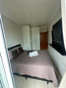 una piccola camera da letto con un letto e una TV a schermo piatto di Apartamento de Dois quartos no centro de Boituva! a Boituva