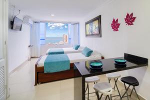 een slaapkamer met een bed en een tafel met krukken bij Marèlago Apartamentos in Cartagena