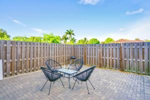 a patio with two chairs and a table in front of a fence at Spacious Townhouse W Free Parking in Miami