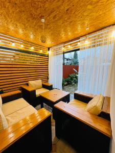 a room with two beds and tables and a window at Sweet Home Tskaltubo Family Guesthouse Near Spa Park in Tsqaltubo