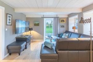 un soggiorno con un divano e una TV di Haus Frieda a Aventoft