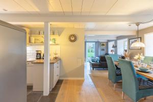 una cucina e un soggiorno con tavolo e sedie di Haus Frieda a Aventoft