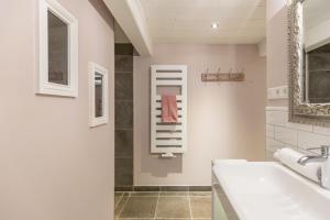 un bagno bianco con lavandino e specchio di Haus Frieda a Aventoft Altre 38 foto