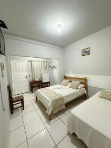 een slaapkamer met twee bedden en een tafel en een stoel bij Hotel Monte Carlo - Cáceres in Cáceres