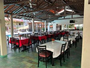 a restaurant with tables and chairs with red chairs at Hotel Pousada Dos Ventos in Parnaíba