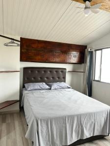 a bedroom with a large bed with a wooden headboard at Casinhas da toca in Búzios