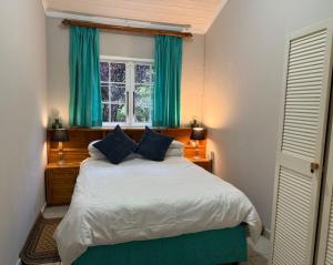 En eller flere senge i et værelse på Esigodini Cottage