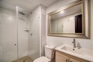 een badkamer met een toilet, een wastafel en een spiegel bij Marèlago Apartamentos in Cartagena +49 foto's
