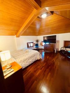 Attico in centro في أوديني: غرفة نوم بها سرير وسقف خشبي