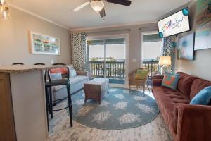 ein Wohnzimmer mit Couch und Bar in der Unterkunft Sea Cabins 342C in Isle of Palms