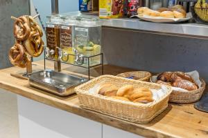 eine Theke mit Körben mit Brot und Gebäck darauf in der Unterkunft Hotel Comenius in Berlin