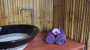 lavandino e 2 asciugamani su un bancone in legno accanto a una vasca da bagno di Lazy Days Bungalows a Ko Lanta