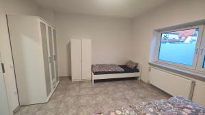 ein Schlafzimmer mit einem Bett, einem Fenster und einem Stuhl in der Unterkunft Urlaub am Rhein Speyer Hockenheim Mannheim in Altlußheim