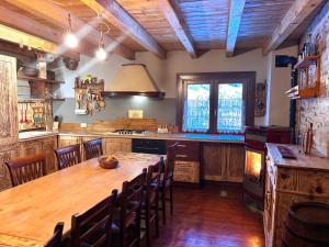 een grote keuken met een houten tafel en stoelen bij Baita immersa nella natura in Borno