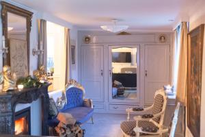 a living room with two chairs and a fireplace at Petit Château luxe vakantiehuis, prive hottub en zwembad in Heythuysen