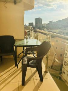 a table and chair on a balcony with a view at Sunshine in Budva