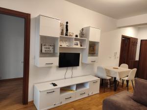 a white living room with a tv on a wall at Sunshine in Budva