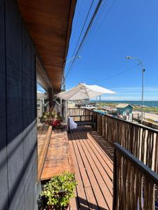 een houten terras met een parasol op het strand bij La Mar de Filomena in Tomé