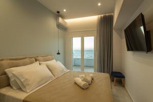 ein Schlafzimmer mit einem Bett, auf dem ein Stofftier liegt in der Unterkunft On The Waves Suites in Korinthos