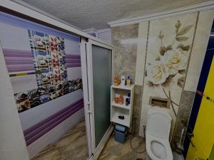 Un baño con inodoro y flores en la pared. en Beny SeaBeach Residence, en Belle Mare 28 fotos más
