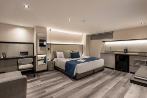 a hotel room with a bed and a desk and a couch at Altus Hotel in Medellín