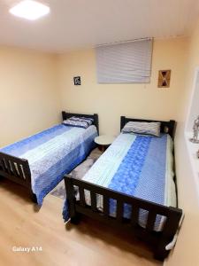 2 Betten in einem kleinen Zimmer mit einem Tisch in der Unterkunft Casa Completa Charmosa e Perfeita para Você in Caxias do Sul