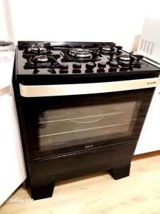 einen schwarzen und weißen Herd mit Backofen in der Küche in der Unterkunft Casa Completa Charmosa e Perfeita para Você in Caxias do Sul