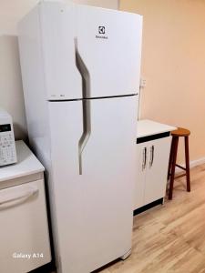 einen weißen Kühlschrank mit Gefrierfach in der Küche in der Unterkunft Casa Completa Charmosa e Perfeita para Você in Caxias do Sul