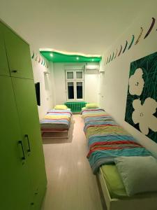 een kamer met drie bedden erin met groene lichten bij Pop Art in Belgrado