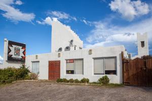 un edificio bianco con un cartello sul lato di Desert Tracks Rancho a Las Grutas