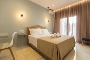 ein Schlafzimmer mit einem Bett, auf dem zwei Handtücher liegen in der Unterkunft On The Waves Suites in Korinthos