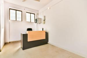 ein Büro mit einem Schreibtisch in einem Zimmer mit weißen Wänden in der Unterkunft Hotel O AG Colony Park Patna Formerly Capital Pearl in Patna