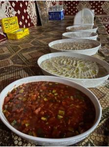 a row of bowls of food on a table at Wadi Rum Bedoun in Wadi Rum +31 photos