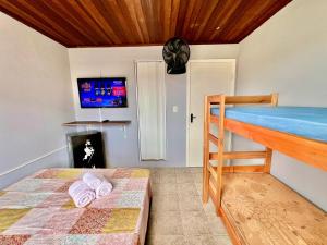 ein Schlafzimmer mit einem Etagenbett und einem TV in der Unterkunft #PéNaAreia em Matinhos Beach in Matinhos + 27 Fotos