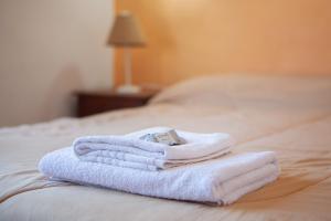 een stapel handdoeken bovenop een bed bij Desert Tracks Rancho in Las Grutas