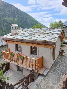 een klein huis met een veranda en een balkon bij La Boschera in Champoluc