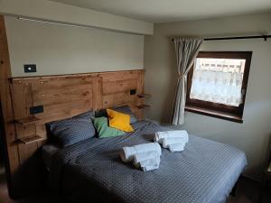 een slaapkamer met een bed met twee handdoeken erop bij La Boschera in Champoluc