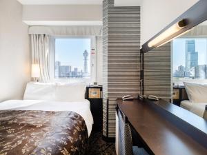 大阪市にあるアパホテル〈なんば南 恵美須町駅〉（新世界）のベッドと机があるホテルの部屋