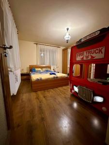 una camera con un letto e un camion dei pompieri rosso di Căsuța Tenu a Craiova