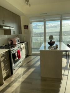 a kitchen with a stove and a counter with a table at Modern Private Room with Ensuite in Vaughan