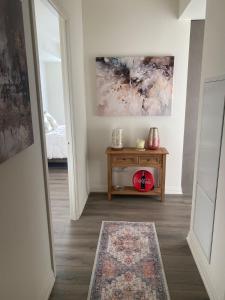 a hallway with a table and a painting on the wall at Modern Private Room with Ensuite in Vaughan +1 photo