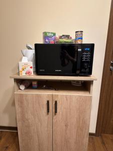 un forno a microonde sopra un mobile in legno di Căsuța Tenu a Craiova Altre 5 foto