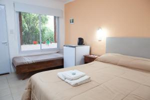 una camera d'albergo con due letti e una finestra di Desert Tracks Rancho a Las Grutas