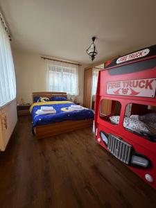 una camera da letto con un letto rosso tipo camion dei pompieri e un letto di Căsuța Tenu a Craiova